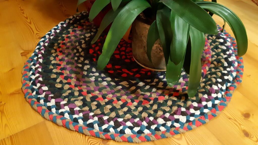 DIY Teppich aus aneinander gesteppten Flechtschnüren mit Zimmerpflanzen.