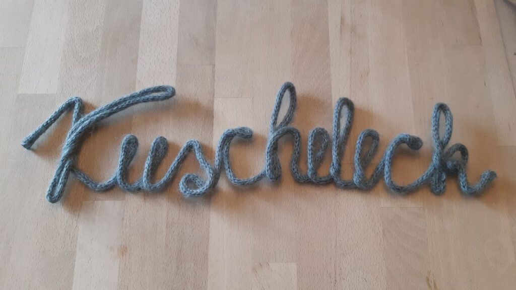 Der DIY Schriftzug aus einem mit Kabel gefülltem Strickschlauch hält nach dem biegen und bleibt in Form.