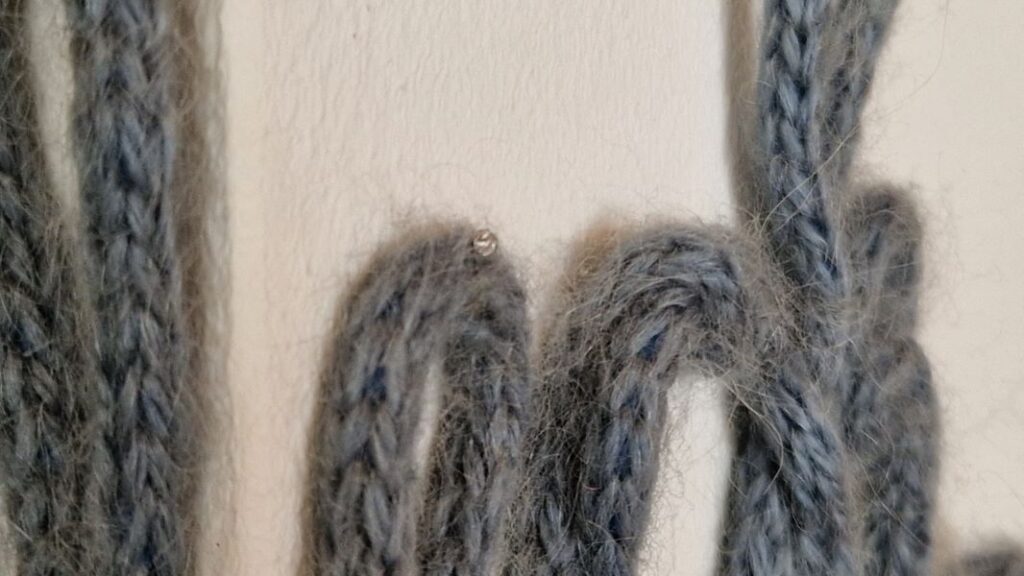 Der DIY Schriftzug aus Wolle wird am besten mit kleinen Nägeln an der Wand befestigt.