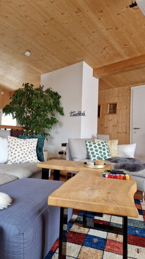 DIY Schriftzug aus Wolle als Wanddekoration im Wohnzimmer neben der Couch.