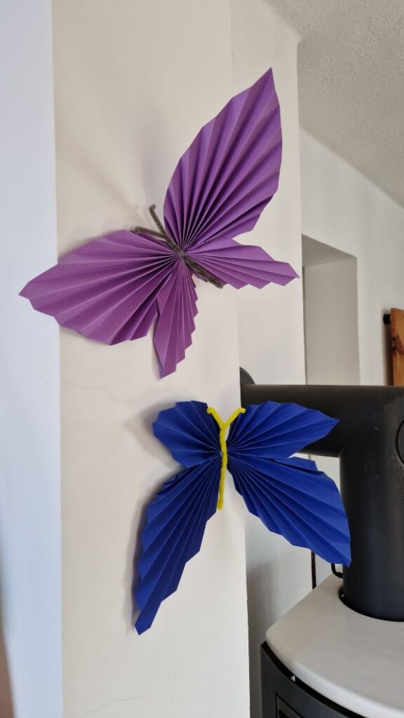 Faltschmetterlinge als Wanddekoration.