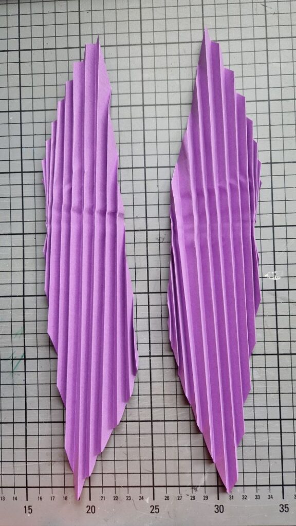 Zwei Blätter violettes, zur Ziehharmonika gefaltetes Buntpapier.
