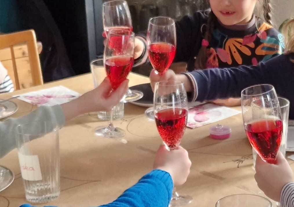 Kinder mit Kindersektgläsern beim Prosten.