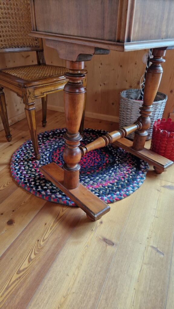DIY Teppich aus aneinander gesteppten Flechtschnüren unter dem alten Schreibtisch und Biedermeierstuhl im Wohnzimmer.