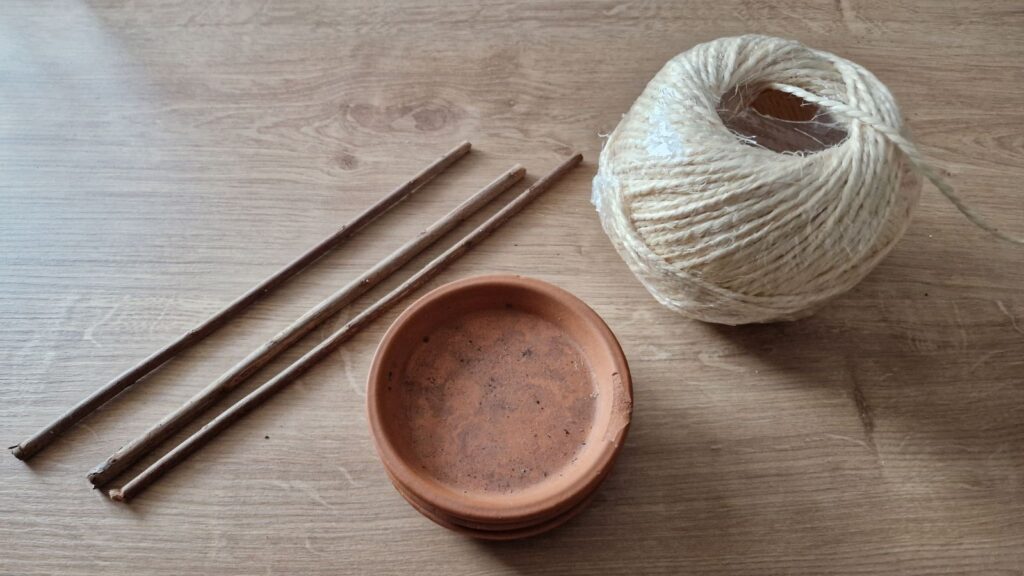 Für die DIY Topfuntersetzter-Macramé Futterstation benötigst Du nur einen Untersetzter, Gartenschnur und ein paar Stöcke.