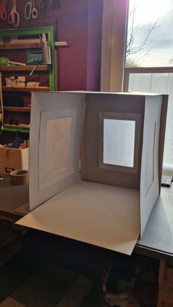 Der erste Testaufbau. Die fünf Kartonteile bilden aneinander- und aufeinander gelehnt eine DIY Fotobox.