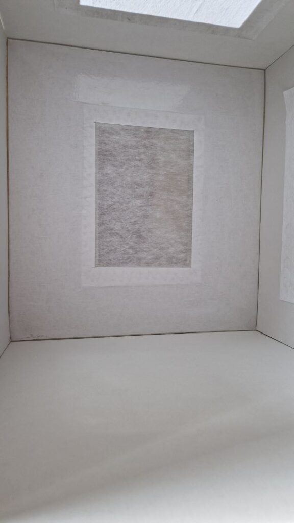 Hier sieht man die DIY Fotobox (Lichtbox). An der Rückwand ist Bucheinbandfolie angebracht. Dadurch kann ich Hintergrundpapier rückstandslos wechseln.