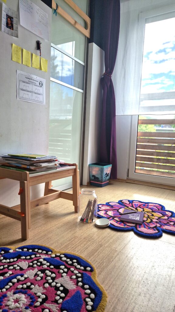 Kinderzimmer mit Teppichen, Schrankwand und Schulbüchern