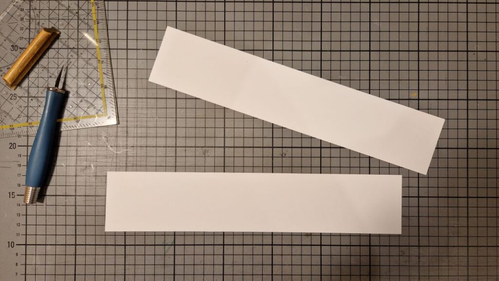 Papierstreifen auf den Deckel und Boden aufgeklebt, dienen später zum Fixieren der Seitenwände.