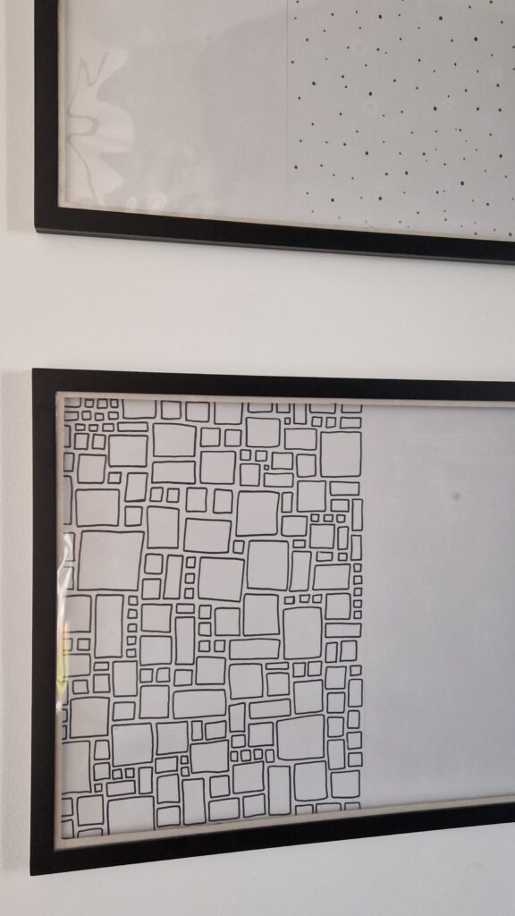 Die DIY Wechselrahmen für Kinderkunst sehen an der Wand durch den einfachen grafischen schwarz-weiß Hintergrund auch schon ohne Bilder nett aus.