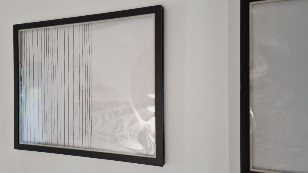 Die DIY Wechselrahmen für Kinderkunst sehen an der Wand durch den einfachen grafischen schwarz-weiß Hintergrund auch schon ohne Bilder nett aus.
